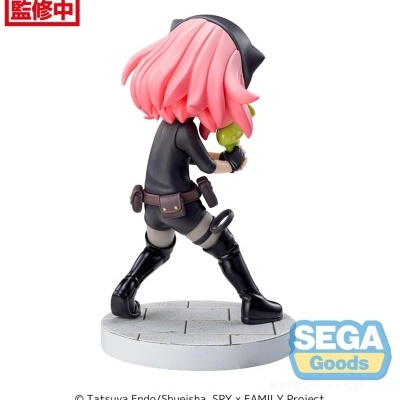 Figura da personagem Anya Forger com cabelo rosa e roupa preta segurando uma pequena figura verde.