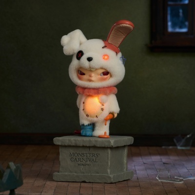 Figura colecionável branca com orelha castanha e luzes, base com texto MONSTERS CARNIVAL HIRONO