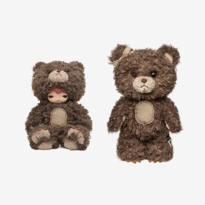 Dois bonecos de pelúcia castanhos com textura felpuda e parches bege