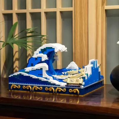 Miniatura de bloco de construção representando uma onda azul e branca com espuma, base decorada a dourado