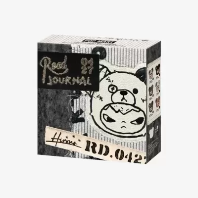 Caixa quadrada cinzenta com desenho de urso estilizado e textos Road JOURNAL 04 27 RD.042