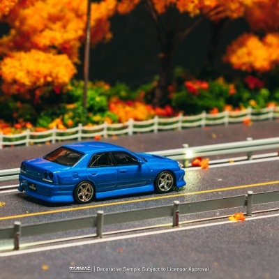 Carro em miniatura azul em estrada com árvores de outono
