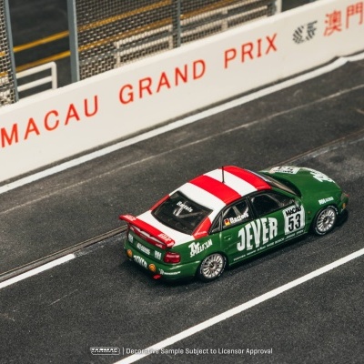 Miniatura de carro de corrida verde com detalhes em branco e vermelho numa pista de corrida com barreira MACAU GRAND PRIX