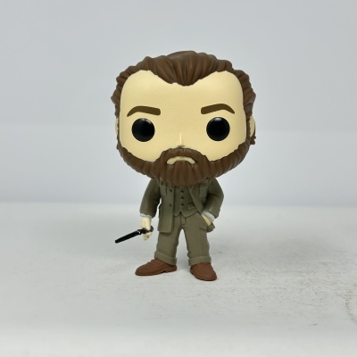 Figura Funko Pop masculina com cabelo castanho e barba, vestida de verde caqui, com sapatos castanhos e segurando objeto preto.