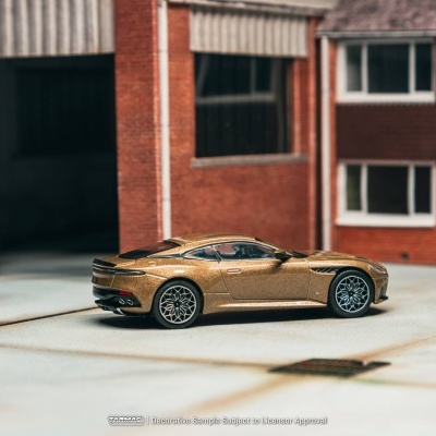Miniatura de carro desportivo dourado junto a edifícios de tijolo
