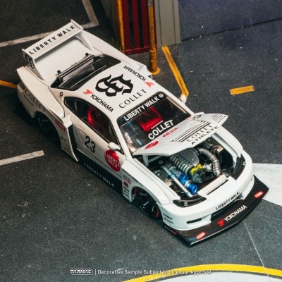 Miniatura de carro de corrida branco com motor visível e várias inscrições e autocolantes.
