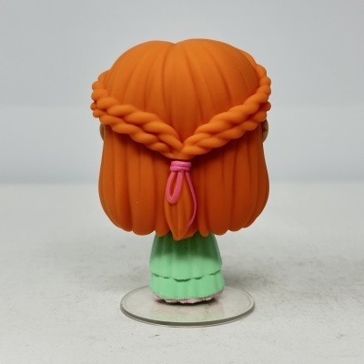 Boneco de vinil com cabelo e vestido verde visto de costas