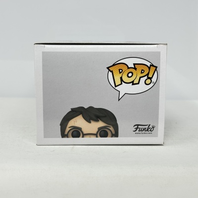 Caixa Funko Pop branca com personagem de cabelo preto, óculos e cicatriz na testa