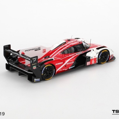 Miniatura de carro de corrida Porsche 963 em escala 1:43 com cores vermelhas, pretas e brancas.