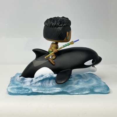 Figura de vinil de personagem sentado numa orca sobre base azul de água