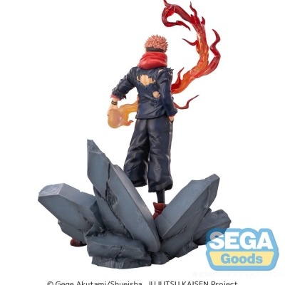 Estátua de personagem anime com chamas e base de pedras cinzentas