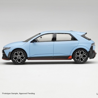 Miniatura de carro azul claro com detalhes pretos e laranja, rodas pretas decorativas, em fundo branco
