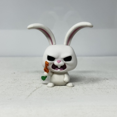 Figura em miniatura de coelho branco com expressão zangada e objecto laranja na mão