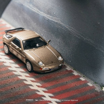 Miniatura de carro desportivo dourado num cenário de pista