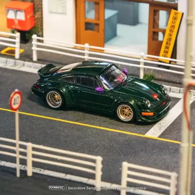 Miniatura de carro desportivo verde metálico com retrovisores roxos e jantes douradas numa rua