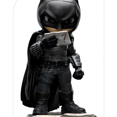 Figura colecionável do Batman em traje preto segurando carta com ponto de interrogação