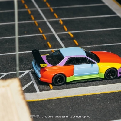 Carro de modelo em miniatura multicolorido estacionado num parque de estacionamento.
