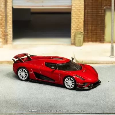 Miniatura de carro desportivo vermelho metálico numa cena urbana em miniatura