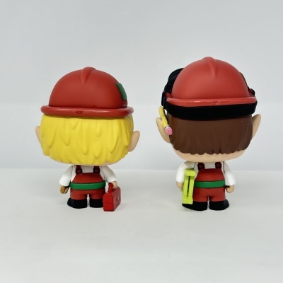 Duas figuras de vinil de trabalhadores de construção civil vistas de costas com capacetes vermelhos.