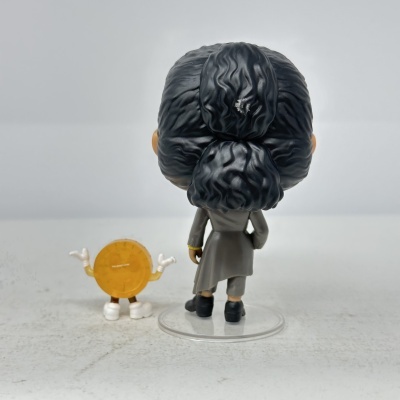 Duas figuras de brinquedo vistas de costas, uma maior com casaco cinzento e cabelo preto e outra pequena redonda amarela com braços e pernas.