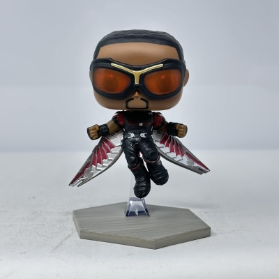 Figura Funko Pop com asas metálicas vermelhas e prateadas e óculos vermelhos