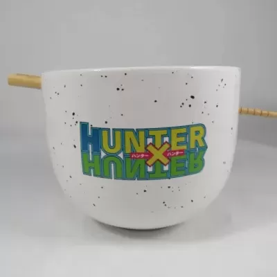 Caneca branca com texto colorido Hunter x Hunter e palito de madeira como alça.