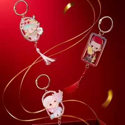 Três porta-chaves coloridos com personagens de anime em fundo vermelho