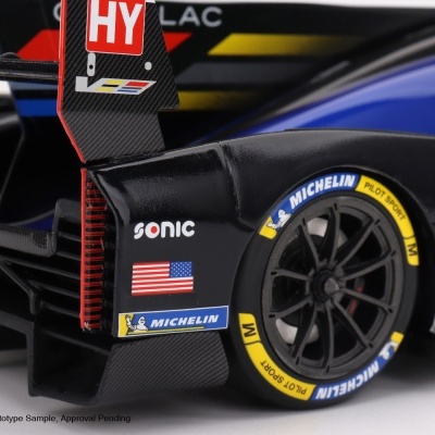 Modelo de carro de corrida preto com detalhes em azul, amarelo e logos Michelin e bandeira dos EUA