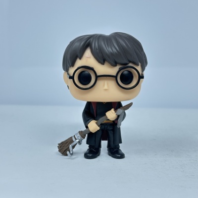 Figura Funko Pop com óculos redondos e vassoura