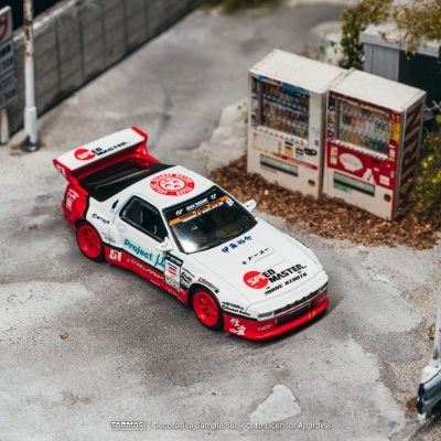 Miniatura de carro de corrida branco e vermelho ao lado de máquinas de venda automática