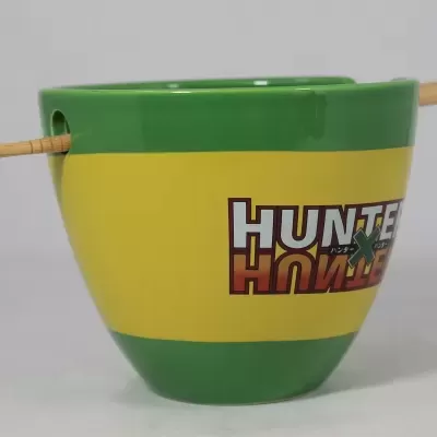 Vaso cerâmico verde e amarelo com escrita HUNTE e suporte de madeira.