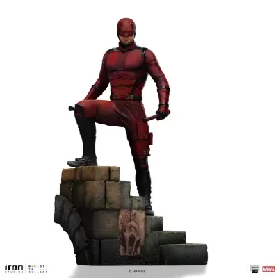 Figurino de personagem vermelho e preto com máscara em base de pedras antigas