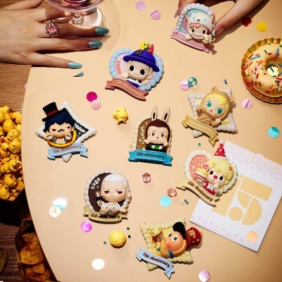 Figuras colecionáveis cartoon coloridas com placa 15th Anniversary sobre mesa bege com pipocas e donut