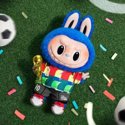 Boneco de pelúcia com camisola colorida e troféu dourado em relva artificial