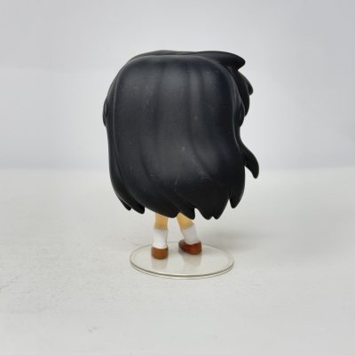 Figura colecionável de personagem vista de costas com cabelo preto e sapatos castanhos