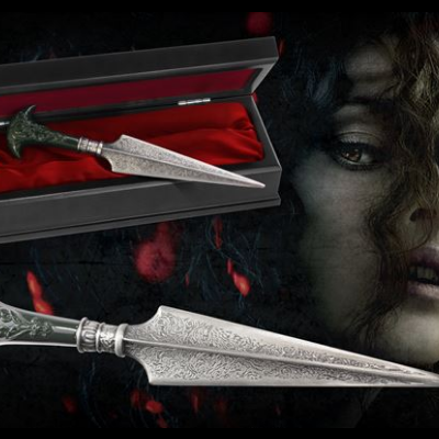 Adaga decorativa com caixa preta e interior vermelho, rosto feminino ao fundo