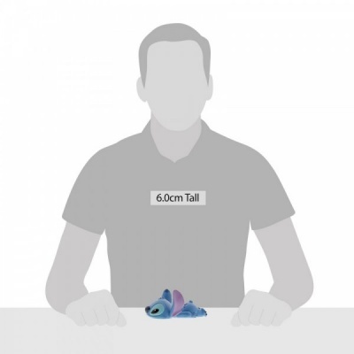 Boneco pelúcia Stitch azul e roxo deitado sobre mesa com etiqueta 6.0cm