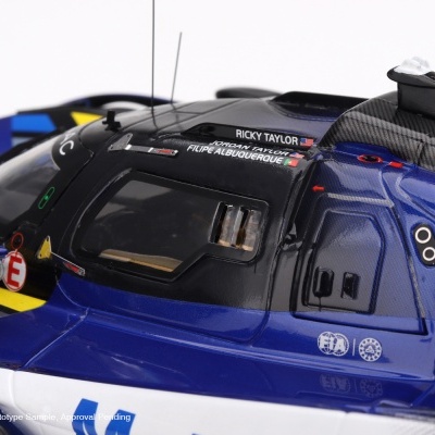 Miniatura de carro de corrida azul, preto e branco com detalhes e nomes dos pilotos