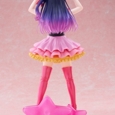 Figura colecionável com cabelo roxo e roupa colorida sobre base de estrelas cor de rosa