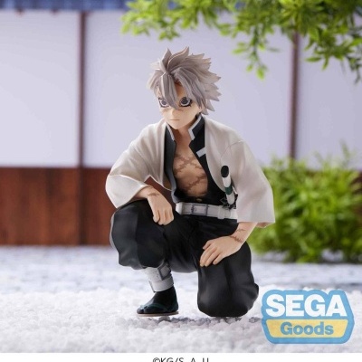 Figura colecionável de personagem masculino com casaco branco e calças pretas, agachado em ambiente exterior