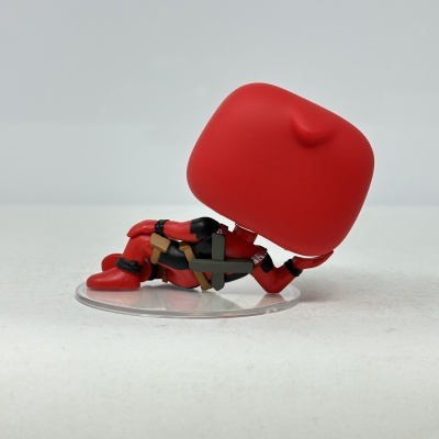 Boneco vinil Deadpool reclinado roupa vermelha e preta em base transparente