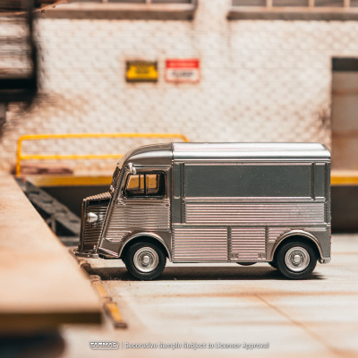 Miniatura de carrinha de metal prateada num cenário urbano