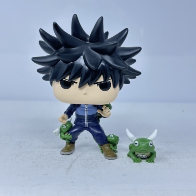 Figura de vinil com cabelo preto espigado e sapos verdes pequenos.