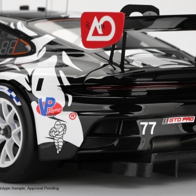 Modelo de carro de corrida preto com detalhes em branco e vermelho, número 77 e asa traseira grande