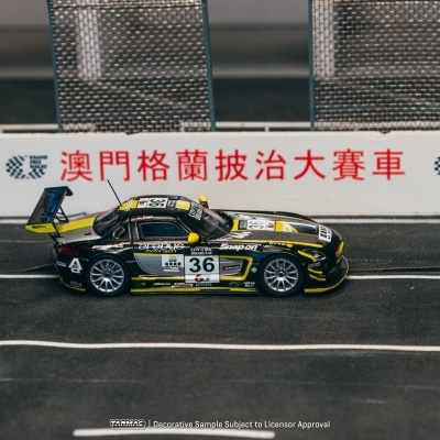 Miniatura de carro de corrida preto e amarelo com número 36 numa pista com barreira e texto em chinês e inglês