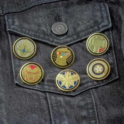 Seis pins metálicos coloridos de Avengers em bolso de casaco de ganga cinzento