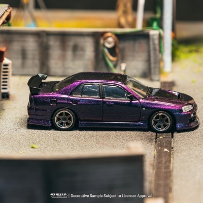 Miniatura de carro desportivo roxo e preto num cenário urbano em miniatura