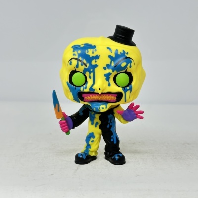 Figura vinil amarela com manchas azuis, olhos verdes e chapéu preto pequeno