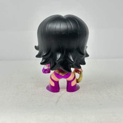 Boneco figura com cabelo preto ondulado e roupa roxa vista de costas