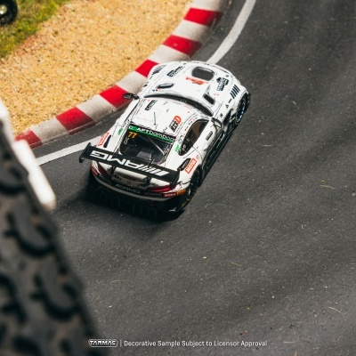Carro de corrida branco com autocolantes AMG e número 77 numa pista curva